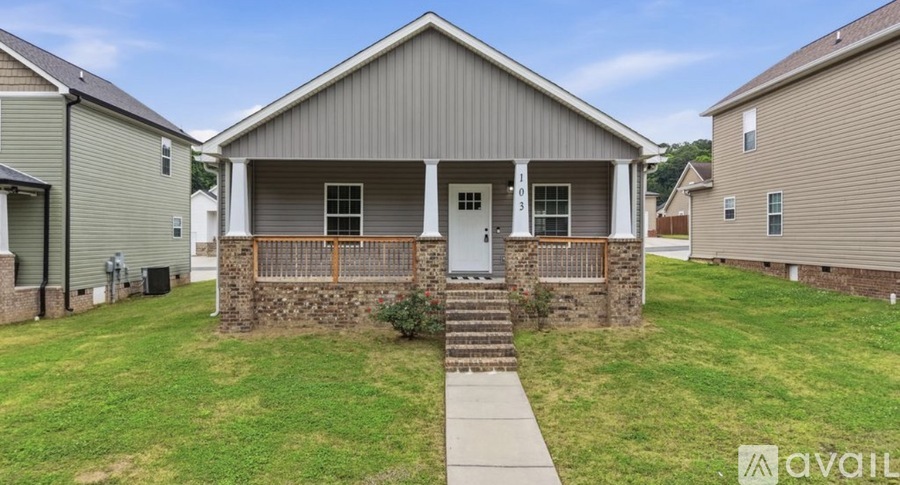 A house with a front yard and a porch is available for rent.