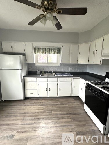 A kitchen with white cabinets and a black stove top oven.