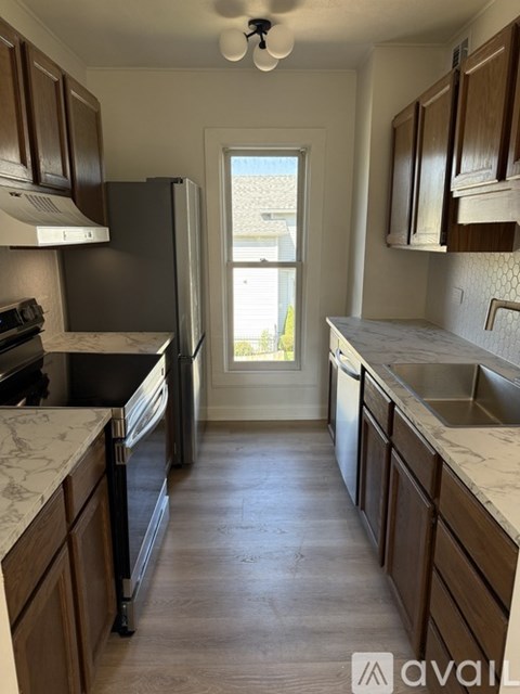 A kitchen with wooden cabinets and a marble countertop.