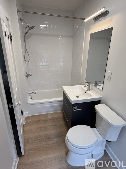A bathroom with a white toilet, sink, and bathtub.