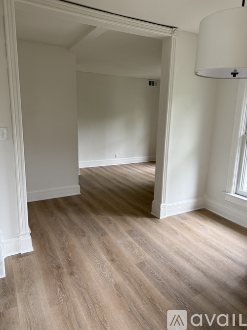 A room with wooden flooring and white walls.