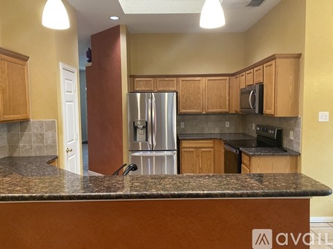 A kitchen with wooden cabinets and a granite countertop.