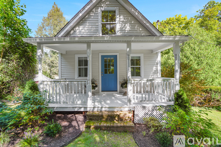 A small white house with a blue door and a porch.