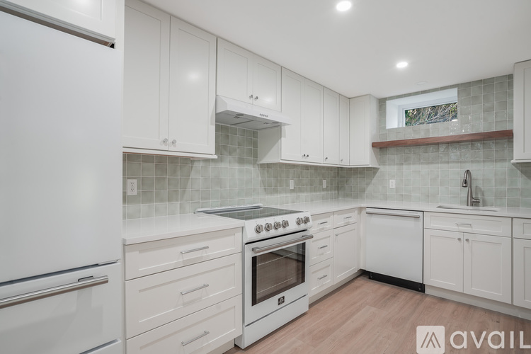 A kitchen with white cabinets and a white fridge.