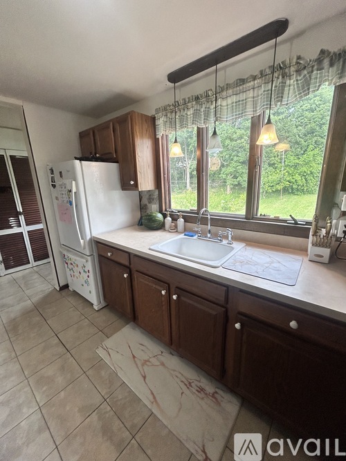 A kitchen with a white fridge and brown cabinets.