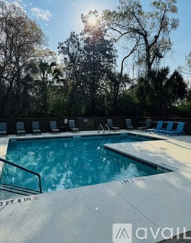 A pool with a depth of 4 feet is surrounded by trees.