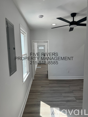 A hallway with a ceiling fan and a sign that says "Five Rivers Property Management.".