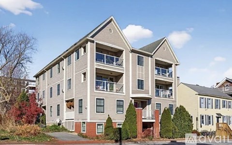A large apartment building with a balcony on the second floor.