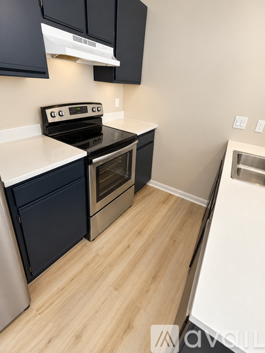 A kitchen with a stove top oven and a refrigerator.