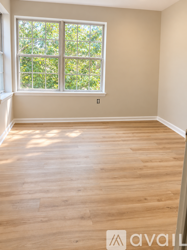 A room with wooden flooring and a large window.