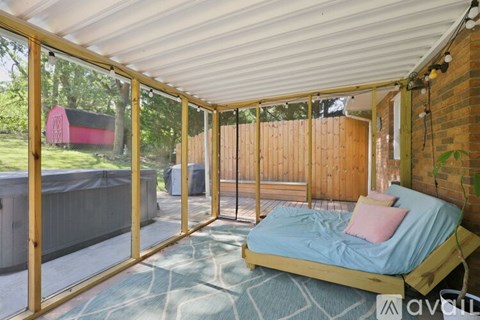 A bedroom with a bed and a window overlooking a backyard.