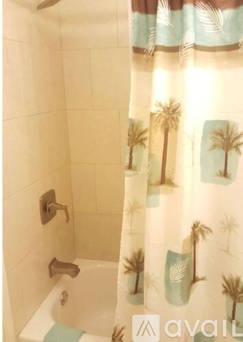 A shower curtain with palm trees on it.