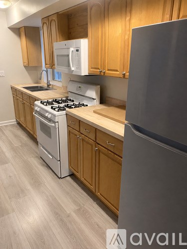 A kitchen with wooden cabinets and a stainless steel refrigerator.