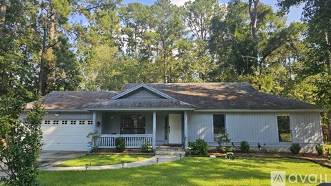 A house with a porch and a garage is for sale.