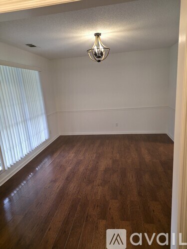 A room with wooden flooring and a light fixture on the ceiling.