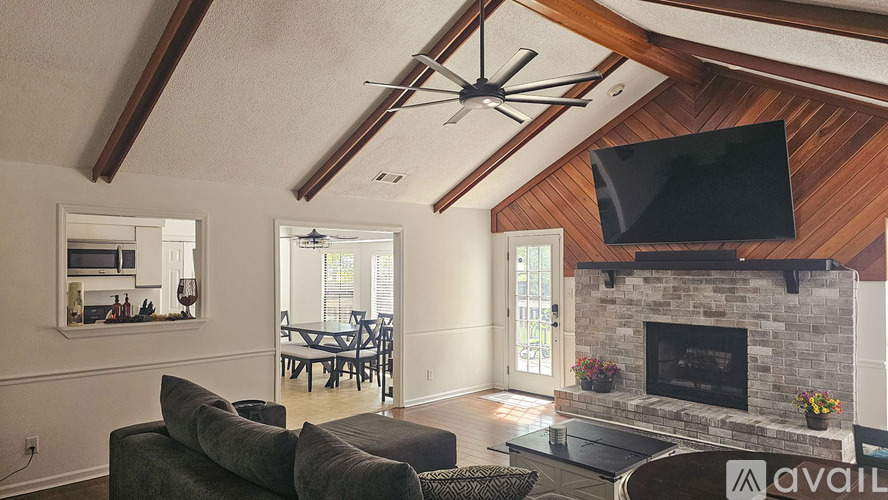 A living room with a fireplace and a television mounted above it.