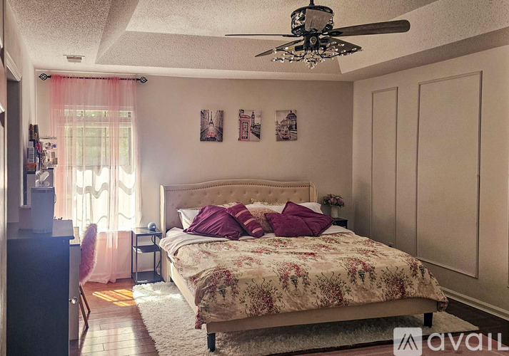A bedroom with a large bed and a ceiling fan.