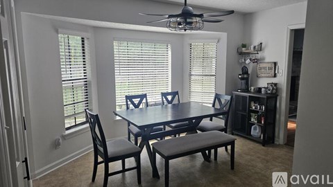 A dining room with a table, chairs, and a ceiling fan.