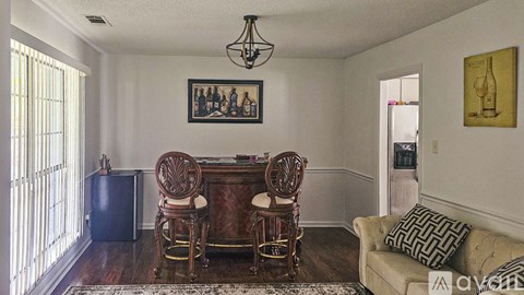 A dining room with a wooden table and chairs.