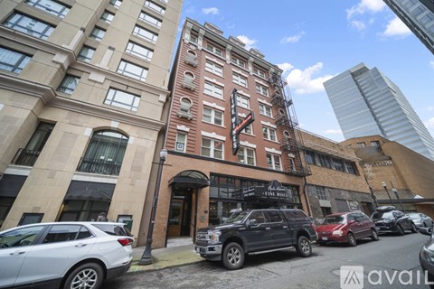 A street view of a building with cars parked in front.