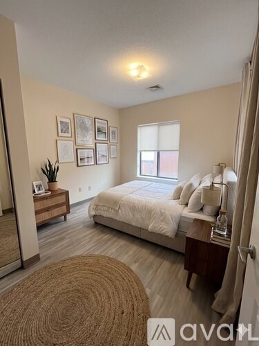 A bedroom with a bed, nightstand, and a rug.