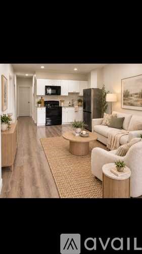 A modern living room with a black refrigerator and a white sofa.
