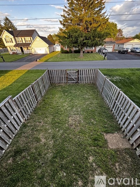 A backyard with a wooden fence and a grassy area.