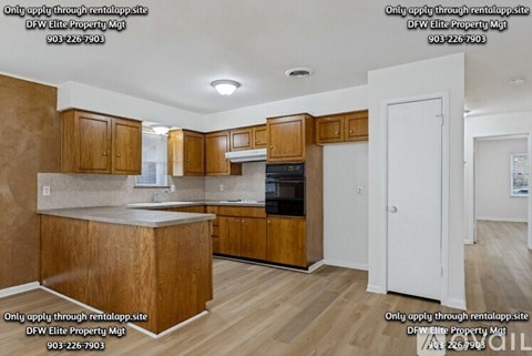 A kitchen with wooden cabinets and a countertop is shown.