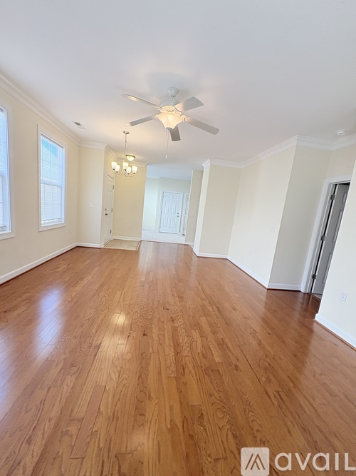 A room with wooden flooring and a ceiling fan.