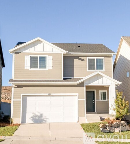 A two-story house with a garage and a driveway.