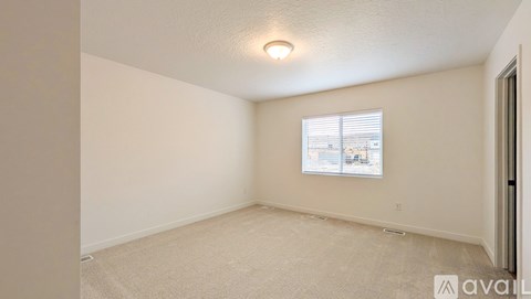 A room with a window showing a view of buildings outside.