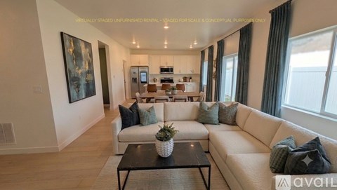 A modern living room with a white sofa, a coffee table, and a painting on the wall.