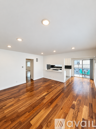 A spacious room with wooden flooring and a white ceiling.