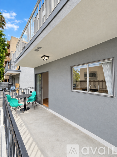 A balcony with a table and chairs overlooks a building.