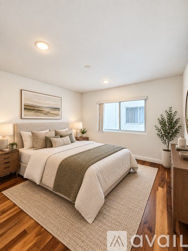 A bedroom with a large bed and a painting on the wall.
