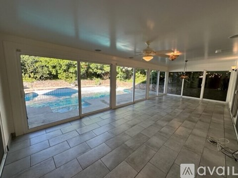 A spacious room with a pool visible through the sliding glass doors.