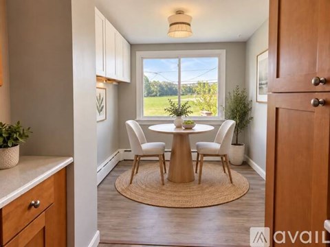 A dining room with a round table and chairs.
