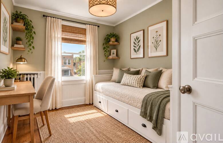 A cozy bedroom with a window seat and a bed with a green throw.