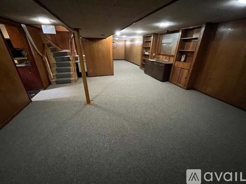 A spacious room with wooden furniture and a carpeted floor.