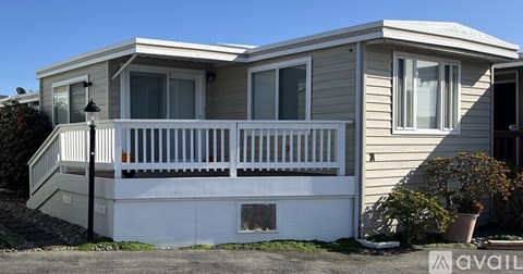 A two-story house with a balcony and a porch.