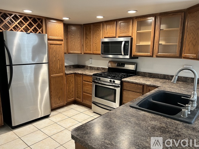 A kitchen with a stainless steel refrigerator, microwave, oven, and sink.