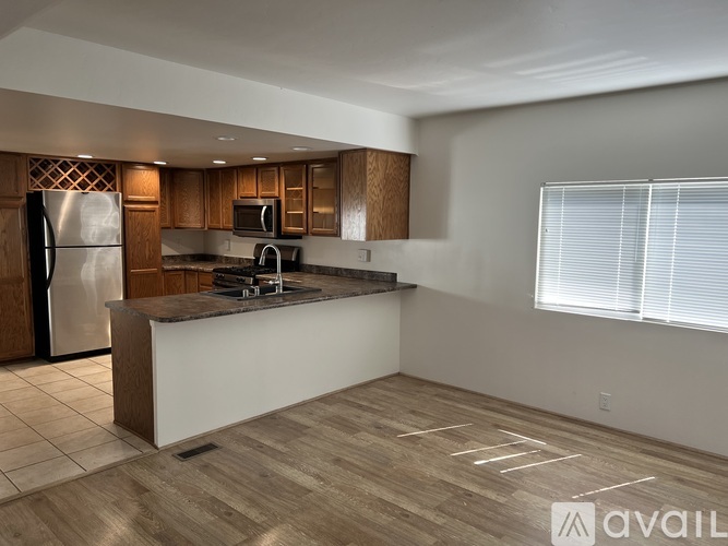 A kitchen with a refrigerator, microwave, and oven.
