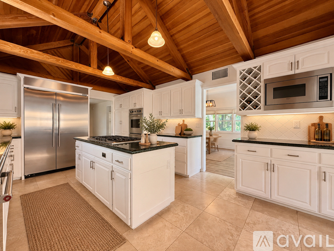 A kitchen with white cabinets and a black countertop.