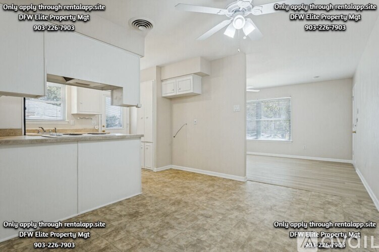 A sparsely furnished room with a fan and a window.
