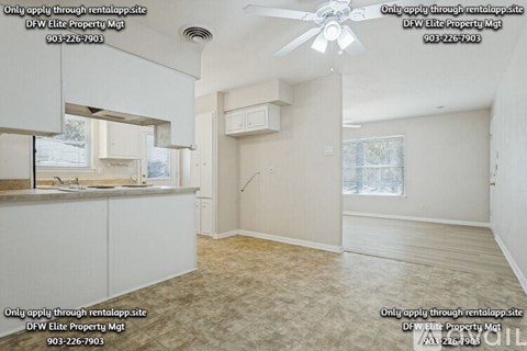 A sparsely furnished room with a fan and a window.