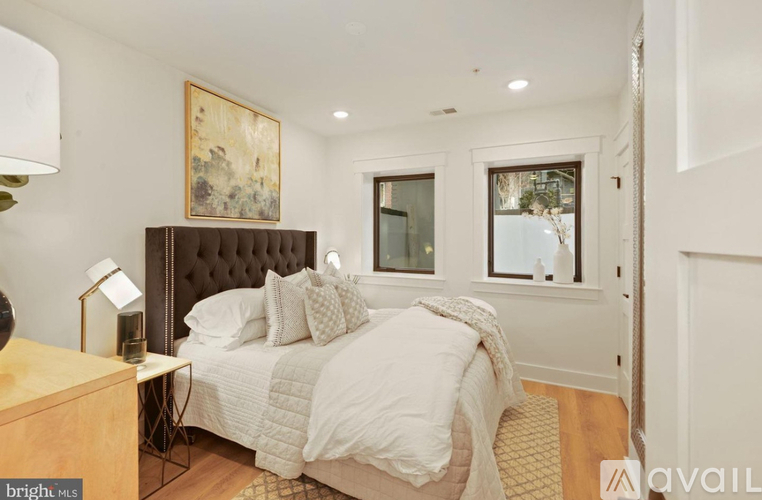 A bedroom with a large bed and a painting on the wall.
