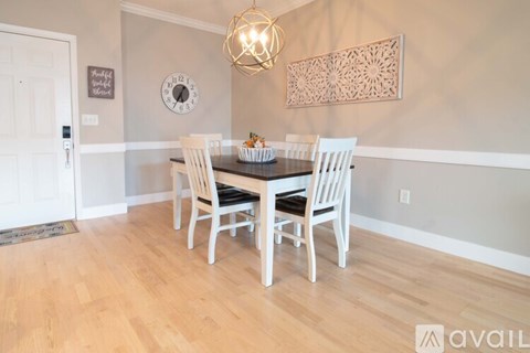 A dining room with a wooden table and chairs.