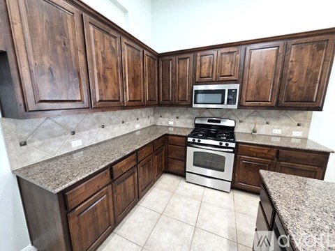 A kitchen with wooden cabinets and a granite countertop.