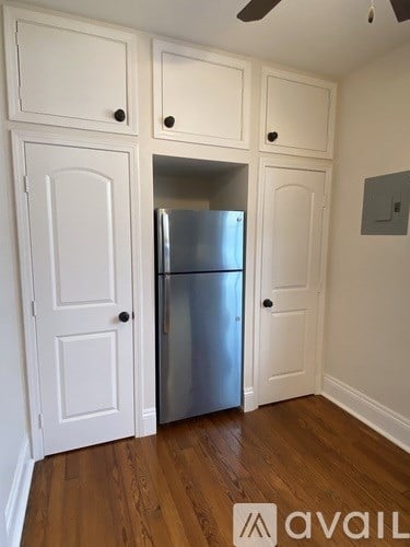 A kitchen with a refrigerator and cabinets.