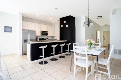 A kitchen with a bar area and a dining table.